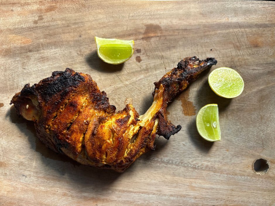 Spiced tandoori chicken on wooden board