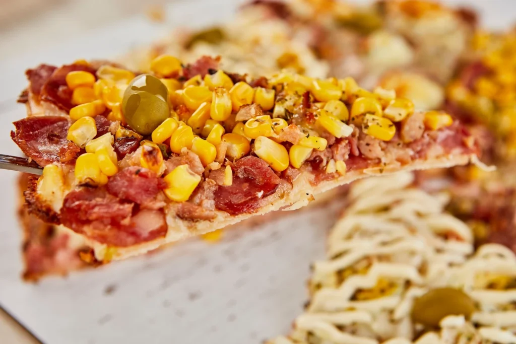 Sliced wedge of tandoori chicken flatbread pizza with cool yogurt drizzle