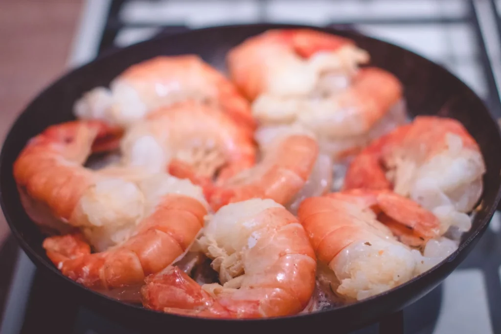 Adding tender shrimp to the simmering coconut curry sauce