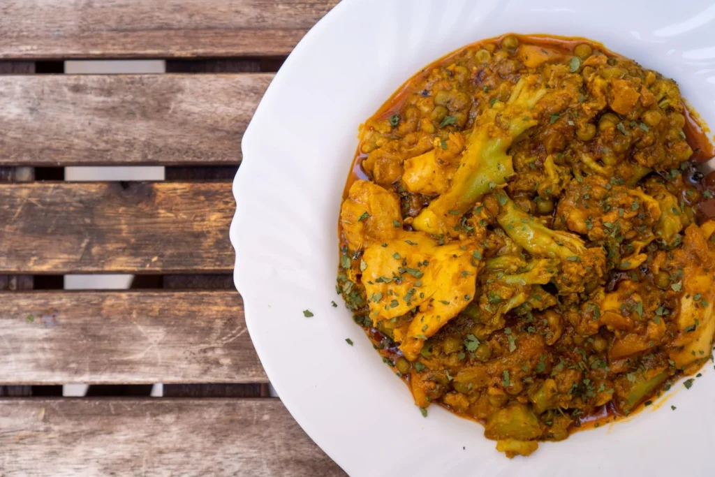 Folding seared mushrooms and sweet green peas into the warm curry sauce