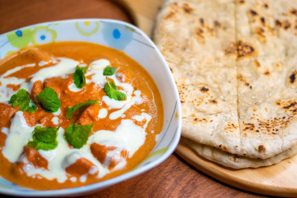 Warm garlic naan scooping up rich matar mushroom curry