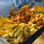 Crispy air-fried onion bhaji fritters stacked with lemon wedges