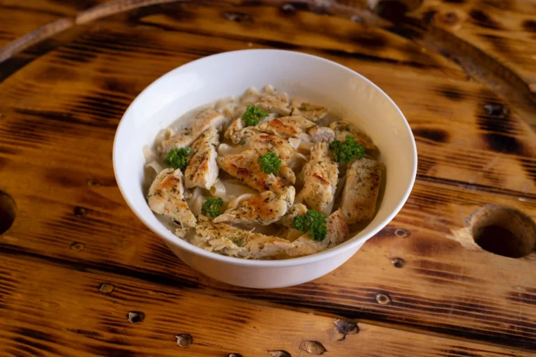 Creamy butter chicken pasta in a bowl with tender chicken and fresh herbs