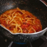Simmering rich creamy butter chicken sauce in a large skillet